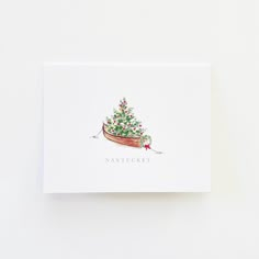 a card with a christmas tree in a boat on the front and words nantuceet above it