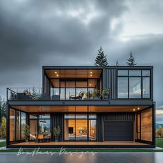 a modern house with glass walls and lots of windows on the top floor is lit up at night