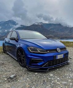 a blue car parked on top of a rocky field