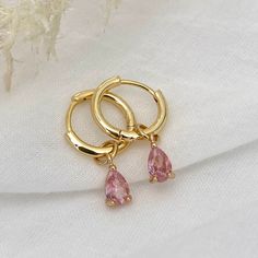 Pink Stunning teardrop cubic zirconia charm with luxurious 14K Gold plated hoop earrings. Gorgeous charms come in 5 different colours Material: 14k Gold plated on Copper, Cubic Zirconia Hypoallergenic Nickel Free and Lead Free Measurement: 24mm in length ,Hoop inner diameter : 11 mm Sold as a pair Gold And Pink Earrings, Gold And Pink Jewelry, Pink And Gold Earrings, Pink Jewellery, Small Earrings Gold, Classy Earrings, Fancy Jewelry Necklace, Silver Jewelry Earrings