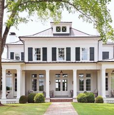 a large white house with black shutters on the front