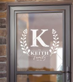 a glass door with the letter k on it and an image of a laurel wreath