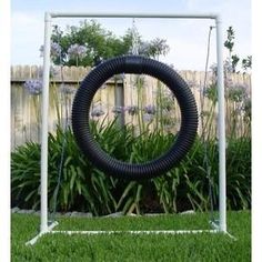 a large black tire sitting on top of a lush green field