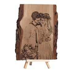 a wooden plaque with an image of a couple kissing on the forehead and flowers in their hair