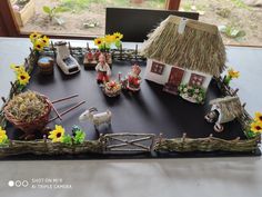 a table topped with a cake covered in fake grass and farm animals on top of it