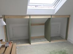 an empty room with unfinished walls and shelves in the corner, next to a window