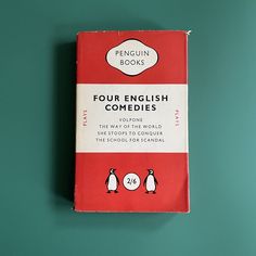 a red book with penguins on it sitting on a green table next to a blue wall