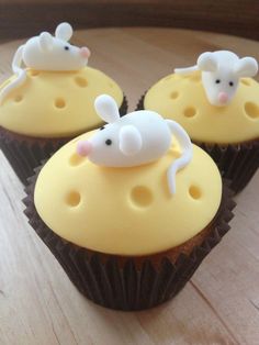 three cupcakes with white frosting shaped like mice