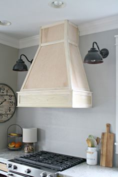 a stove top oven sitting inside of a kitchen next to a wall mounted light fixture