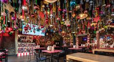 the interior of a restaurant decorated with christmas decorations and ornaments hanging from the ceiling over tables