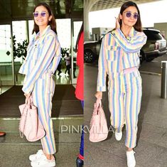 an image of a woman in striped clothing at the airport with her handbag and purse