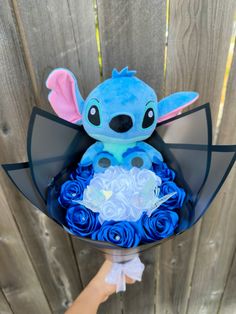 someone is holding a bouquet of blue roses in the shape of stitch - o - life