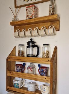 a wooden shelf with cups and mugs on it