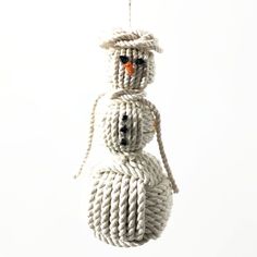 a snowman ornament made out of rope with an orange nose hanging from it