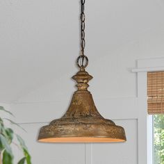 a light fixture hanging from the ceiling in a room with white walls and wooden blinds