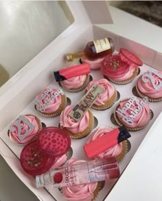 cupcakes with pink frosting and decorations in a box