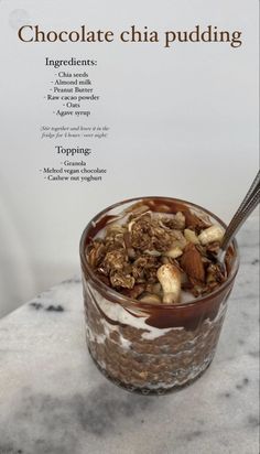 chocolate chia pudding in a glass with nuts and almonds on top, sitting on a marble table