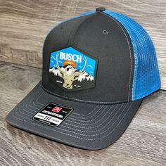 Our Pvc Patch Is A Waterproof, Rugged, And Clean Looking Design. You Can Bet That This Patch Will Look Vibrant For Years To Come. We Only Use The Highest Quality Products And Headwear. We Believe That Our Pvc Patches Beat Out Any Other Type Of Patch Offered On A Hat. Design: Busch Light Mountain Escape Hat: Richardson 112 Color: Charcoal/ Blue Structured, Six-Panel, Mid-Profile 60/40 Cotton/Polyester Adjustable Plastic Snapback Pre-Curved Contrast Stitched Visor Hat Size: 7 - 7 3/4 Nike Outdoor Baseball Cap With Curved Brim, Nike Curved Brim Baseball Cap For Outdoor, Nike Curved Bill Baseball Cap For Outdoor, Blue Trucker Hat For Camping, Blue Trucker Baseball Cap For Outdoor Activities, Blue Flat Brim Baseball Cap For Outdoor Activities, Blue Snapback Hat For Hiking, Nike Outdoor Hats, Nike Outdoor Hats With Curved Brim