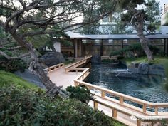 a wooden bridge over a small pond in a garden