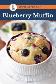 blueberry muffin in a white bowl on a plate with the title cooking for one