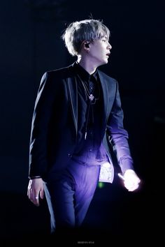 a male in a black suit and purple pants