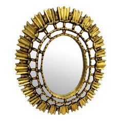 a mirror that is sitting on top of a white surface with gold trimmings