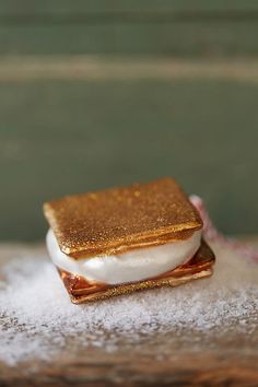 a piece of food sitting on top of a wooden table covered in powdered sugar