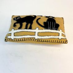 an embroidered pillow with cats on it