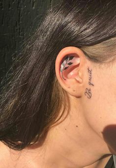 a woman's ear has a tattoo on it