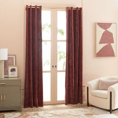 a living room filled with furniture and a large window covered in red drapes