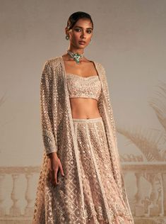 Elevate your festive style with this stunning champagne lehenga set. This exquisite ensemble includes a sparkling champagne heavy lehenga paired with a beautifully embroidered bustier and a chic long jacket. The floral motifs add a touch of grace and charm to the ensemble, making it perfect for any occasion where you want to make a lasting impression. The seamless blend of traditional craftsmanship and contemporary design ensures that you'll turn heads effortlessly. Heavy Lehenga Designs, Lehenga With Long Jacket, Champagne Lehenga, Embroidered Bustier, Heavy Lehenga, Kurta Lehenga, Lehenga Pattern, Ridhi Mehra, Sparkling Champagne