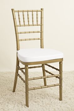 a gold chiavard chair with white seat padding on carpeted flooring