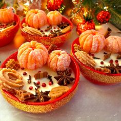 several small red bowls filled with desserts on top of a white table covered in christmas decorations