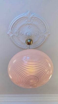 a light fixture hanging from the ceiling in a room with white walls and flooring