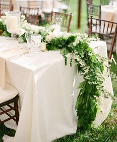 the table is decorated with greenery and candles