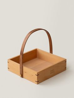 a wooden basket with handle on the side