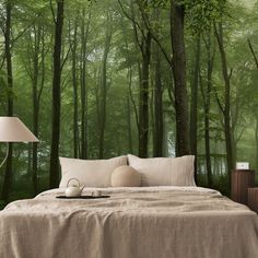 a bed sitting in front of a forest wall mural