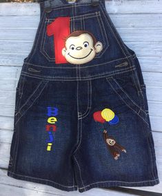 a child's jean shorts with monkey and balloon appliqued on it