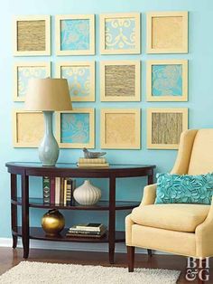 a living room with blue walls and pictures on the wall above the table, along with a yellow chair