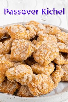 a white bowl filled with powdered sugar covered pastries on top of a table