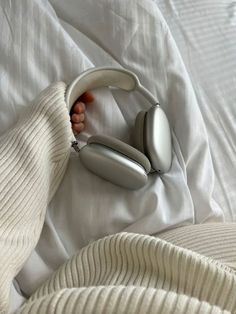 a person is laying in bed with headphones on their ears and one hand under the covers