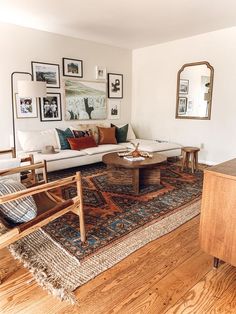 a living room filled with furniture and pictures on the wall above it's coffee table