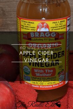 a bottle of apple cider vinegar next to apples