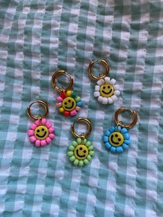 four smiley face key chains on a checkered tablecloth with a gingham cloth