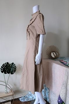 Beautiful Vintage safari dress from the 1990s. Comfortable cotton fabric in a versatile neutral colour, reminiscent of safari or military gear. Featuring a cute ruffle neck, puff sleeves, ruffles along the front, a lined skirt, zipper on the left, side pockets and belt loops. Slightly flared midi skirt. Very comfortable and versatile for warm summer days. BRAND: Betty Barclay COLOUR: Sand FABRIC: 100% cotton SIZE: Vintage size 40, fits best size M (or S for a more relaxed fit) - please check mea Beige Short Sleeve Midi Dress With Ruffles, Beige Midi Dress With Ruffles And Short Sleeves, Casual Beige Midi Dress With Ruffles, Beige Midi Dress With Ruffle Hem And Short Sleeves, Beige Cotton Midi Dress With Puff Sleeves, Flared Midi Skirt, Vintage Safari, Safari Dress, Dress With Puff Sleeves