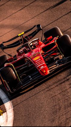 a red race car driving down the track