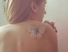 a woman with a butterfly tattoo on her back