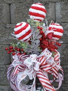 a basket filled with candy canes on top of a brick wall in front of a building