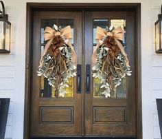 two wreaths on the front door of a house