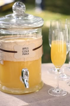 an apple cider punch is sitting on a table with wine glasses